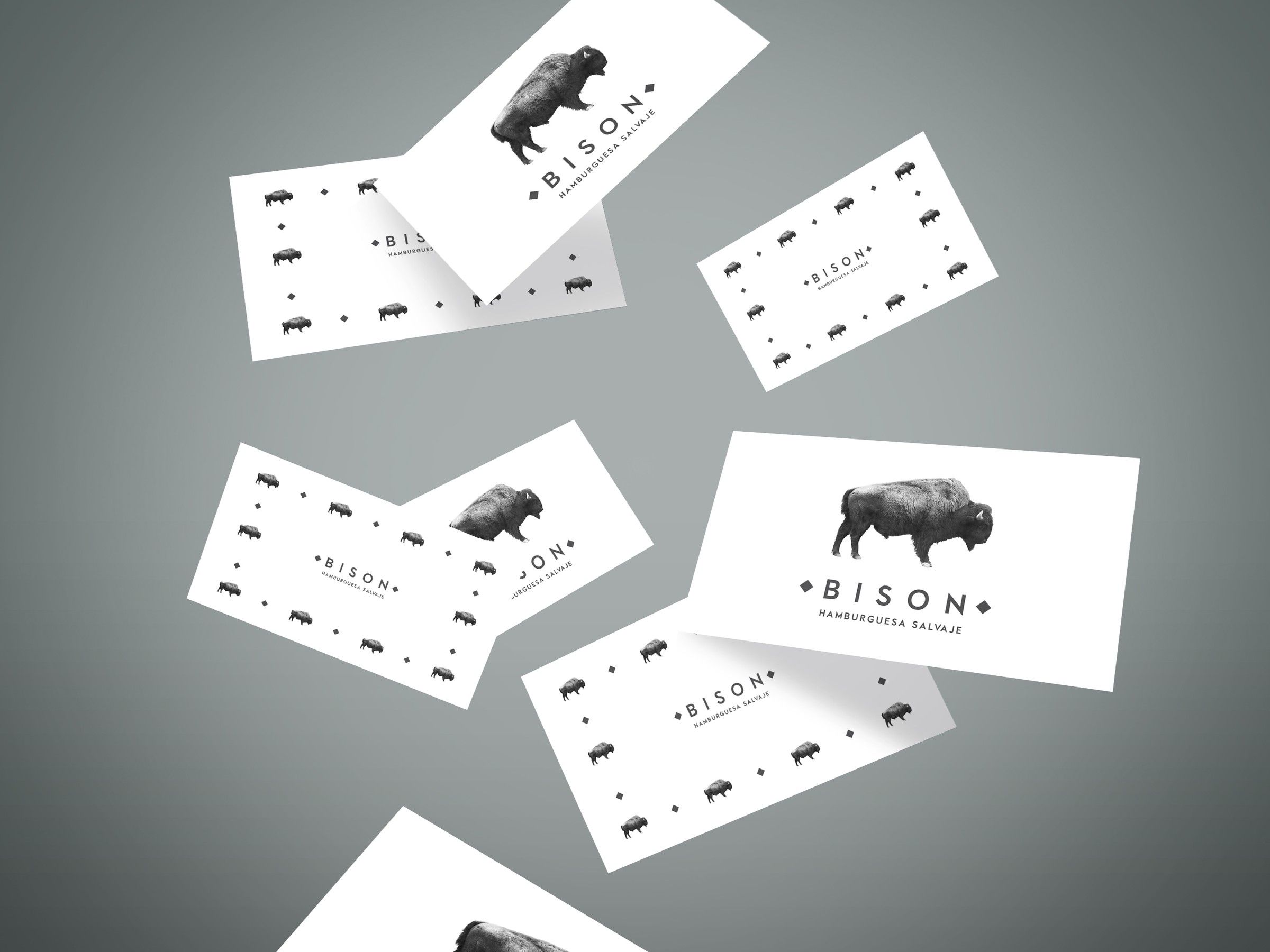 Bison business cards scattered in the air, with the bison silhouette and wordmark