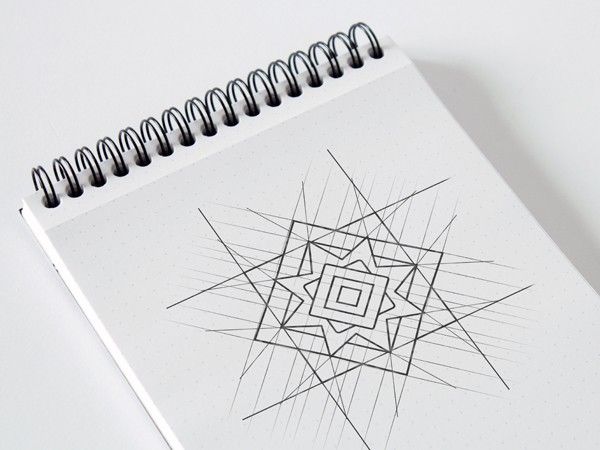 Construction sketch of the eight-pointed star symbol on a spiral notepad