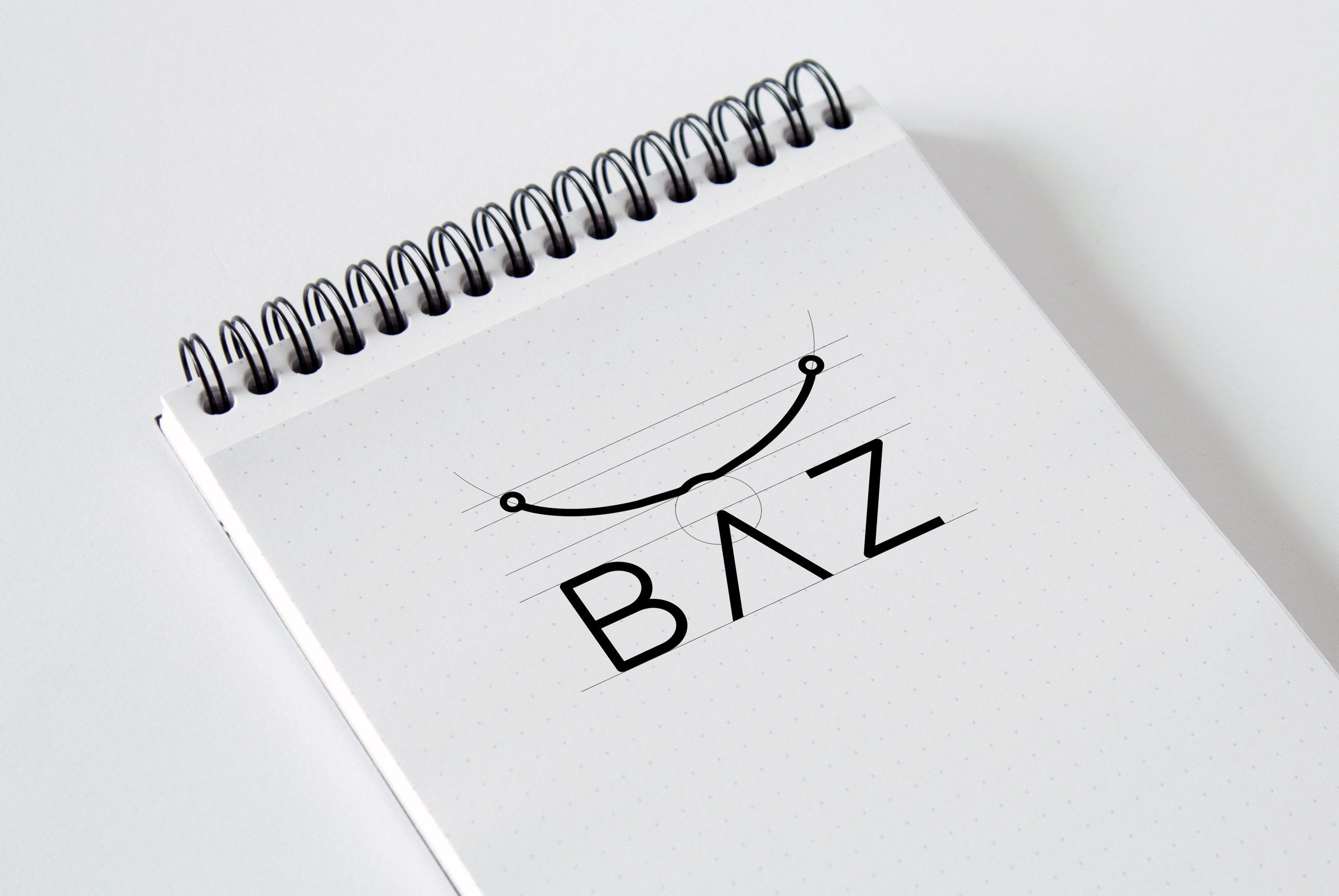 Construction sketch of the BAZ logo on a spiral notepad