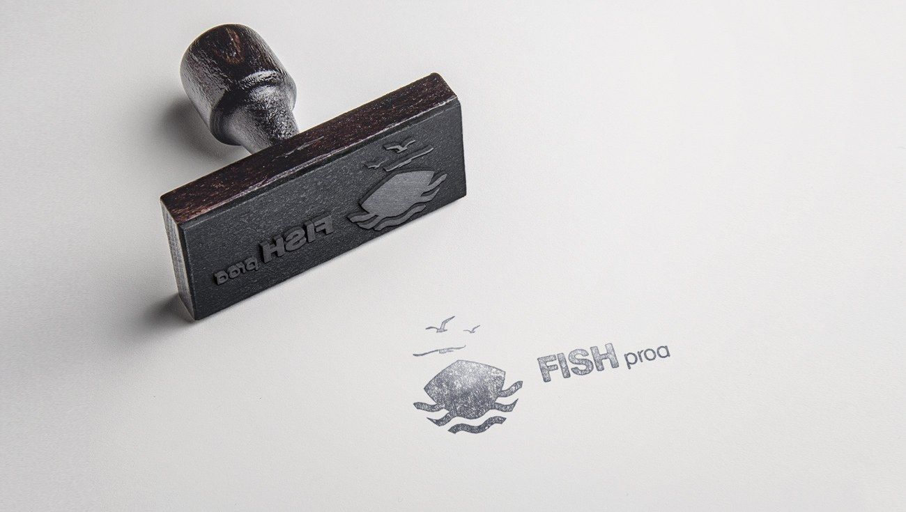Rubber stamp beside a stamped FISHproa logo on paper